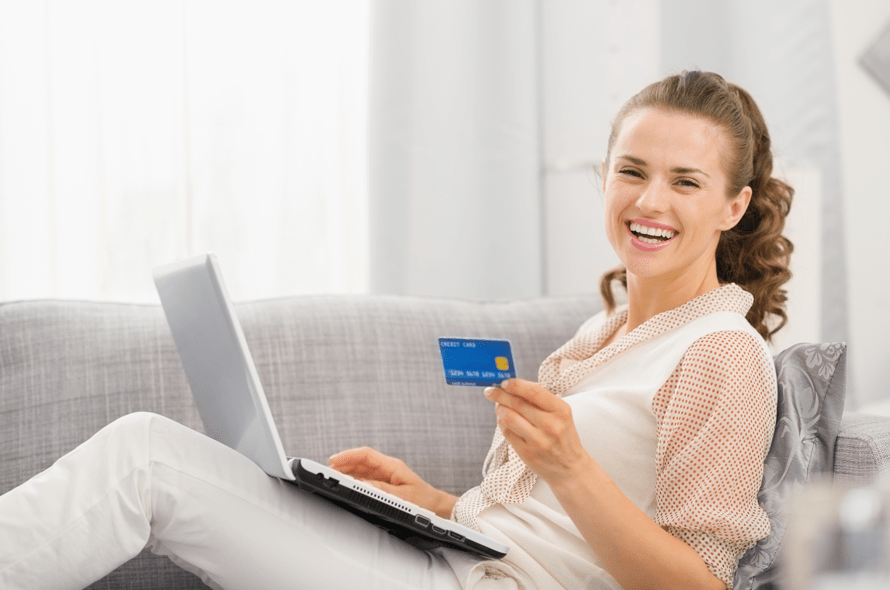 パソコンをしながらクレジットカードを持つ女性