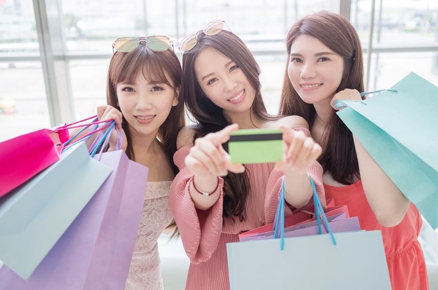 買い物袋を持つ3人の女性とカード