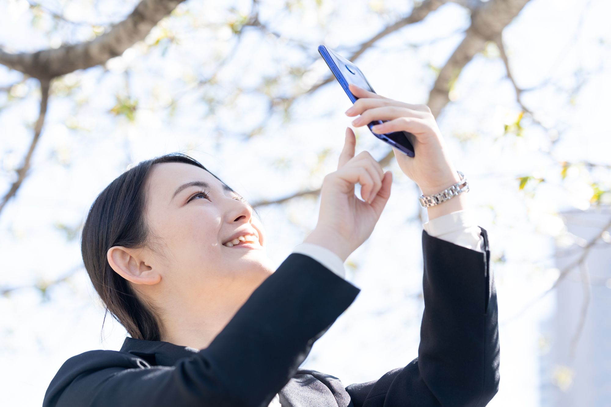 桜を見る新社会人の女性