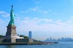 海の向こうに浮かぶニューヨークのビル街と自由の女神