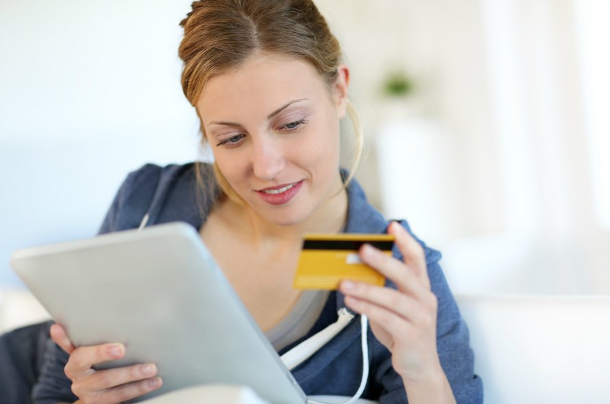 クレジットカードを見つめる若い女性